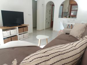 a living room with a couch and a tv at Charming Bungalow in Torrevieja Near La Mata Natural Park in La Mata