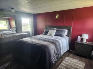 a bedroom with a bed and a red wall at Quiet Cozy Cottonwood Cottage in Scotia in Scotia