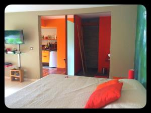 a bedroom with a bed and a kitchen in the background at Aluna Ecolodge in Petit-Bourg