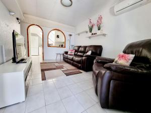 a living room with two leather chairs and a television at Bungalow near the Salt Lakes of Torrevieja and La Mata and their beaches in La Mata