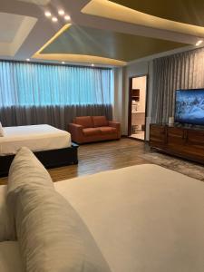 ein Schlafzimmer mit zwei Betten und einer Couch und einem Fernseher in der Unterkunft Family vacation home, 10 miles from downtown Pv romantic zone, ocean frontage in Puerto Vallarta + 159 Fotos