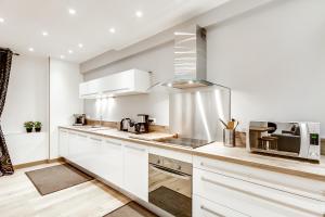 a kitchen with white cabinets and a microwave at Just Renovated 138m2 On The Seine in Paris