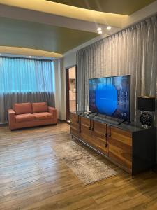 ein Wohnzimmer mit einem TV und einem Sofa in der Unterkunft Family vacation home, 10 miles from downtown Pv romantic zone, ocean frontage in Puerto Vallarta