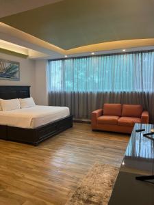 ein Schlafzimmer mit einem Bett und einer Couch und einem Fenster in der Unterkunft Family vacation home, 10 miles from downtown Pv romantic zone, ocean frontage in Puerto Vallarta