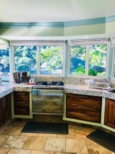 eine Küche mit Fenstern und einer Theke mit einer Spüle in der Unterkunft Family vacation home, 10 miles from downtown Pv romantic zone, ocean frontage in Puerto Vallarta