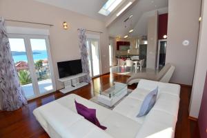 - un salon avec un canapé blanc et une télévision dans l'établissement Apartments Villa Coratina, à Trogir