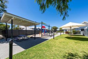 a park with a playground with a slide and umbrellas at Cape View Beach Resort - Endless Summer in Broadwater