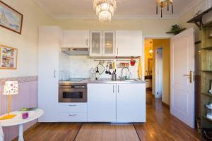 a kitchen with white cabinets and a sink and a table at Apartamento Belén in Las Lagunas