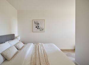 吉朗Urban Drift - Cosy Balcony Nook near Waterfront的白色卧室内的一张白色床,墙上挂着一幅画