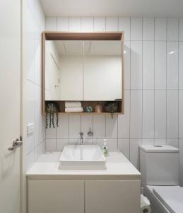 吉朗Urban Drift - Cosy Balcony Nook near Waterfront的一间白色浴室，配有洗手池和镜子。