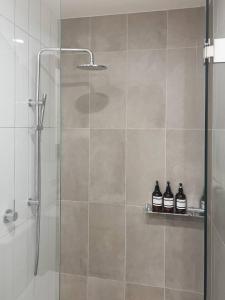 吉朗Urban Drift - Cosy Balcony Nook near Waterfront的浴室设有淋浴,架子上装有三瓶水 更多25张照片
