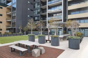 吉朗Urban Drift - Cosy Balcony Nook near Waterfront的楼前的庭院,有长椅和树木