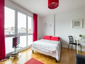 a bedroom with a bed with red pillows and a tv at Studio Part Dieu in Lyon