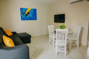 a living room with a couch and a table and chairs at Wonderful 1-bedroom apartment 3 km from Eagle beach in Noord