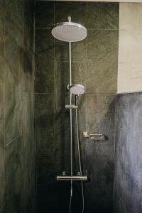 a shower with a shower head in a bathroom at Wonderful 1-bedroom apartment 3 km from Eagle beach in Noord