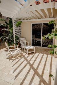 een patio met 2 stoelen en een pergola bij Amazing studio 2 km from Eagle beach in Palm-Eagle Beach
