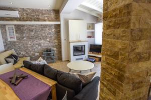 a living room with a stone wall at Villa Angelo ΙΙ in Paleokastritsa