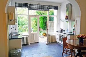 a kitchen with a table and a large window at Bed & Breakfast Walenburg in Rotterdam