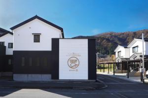 a white building with a sign in the street at パーパスリゾート 越後湯沢 蔵 in Yuzawa