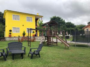 a playground with a slide and chairs in a yard at WaraKusi Country Houses - Ground floor - Off Road in Vaqueros