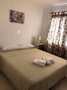 a bedroom with a bed with two towels on it at WaraKusi Country Houses - Ground floor - Off Road in Vaqueros +12 photos