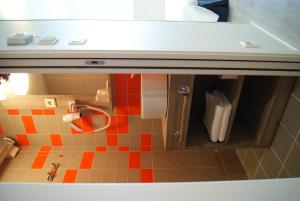 a toy kitchen with a sink and a tile floor at The Originals City, Hôtel Clermont-Ferrand Sud Aubière in Aubière