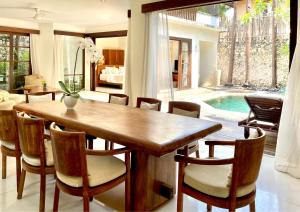 a dining room with a wooden table and chairs at Villa Kubu Seminyak in Seminyak