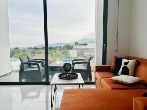 a living room with a couch and a table at B1-14 Crystal Bay Retreat - Pool View Apartment in Ayios Nikolaos