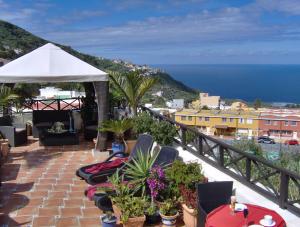 a balcony with chairs and a white umbrella and the ocean at Holiday home to the street with big kitchen in Icod de los Vinos