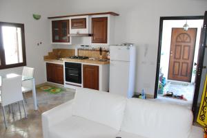 a living room with a white couch and a kitchen at Villetta Saba in Olbia