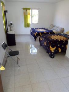 a bedroom with two beds and a chair in it at Lodging And Tranquility in Tlaquiltenango