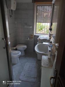 łazienka z umywalką, toaletą i oknem w obiekcie La Rosa - Home Relax w Agropoli