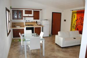 sala de estar con mesa y sofá blanco en Villetta Saba, en Olbia