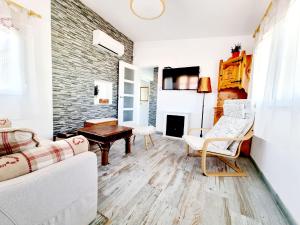 トレビエハにあるCharming Upper Bungalow with Terrace and Communal Pool in Torreviejaの白い家具とレンガの壁が備わるリビングルーム