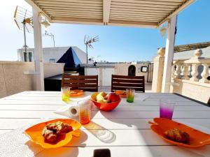 トレビエハにあるCharming Upper Bungalow with Terrace and Communal Pool in Torreviejaのパティオの上にテーブル(食器付)