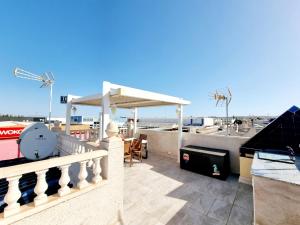 a balcony with a table and a clock on it at Charming Upper Bungalow with Terrace and Communal Pool in Torrevieja in Torrevieja