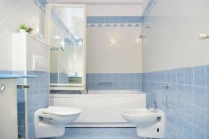 un bagno con vasca, WC e lavandino di Casa Melide Seeblick a Melide