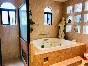 a large bathroom with a tub and a window at Suite Jacuzzi Room in Stunning Villa Playacar Ii in Playa del Carmen +21 photos