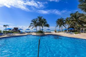 a pool at the resort with palm trees and chairs at Suite Jacuzzi Room in Stunning Villa Playacar Ii in Playa del Carmen