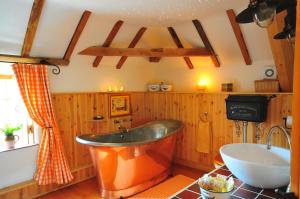 a bathroom with an orange tub and a sink at The Hayloft and Bothy at the Manor House Stables - TWO units in Martin near Woodhall Spa - Dogs Welcome! in Martin +45 photos