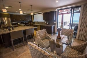 eine große Küche mit einem Tisch, Stühlen und einer Theke in der Unterkunft Spectacular 3 bedroom Penthouse at Crocs Resort Casino in Jacó