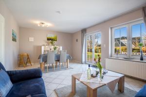 a living room with a blue couch and a table at Bauernhof Lafrenz, Ferienhaus Nelke in Fehmarn