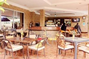 a restaurant with tables and chairs and a counter at The Chelsea Hotel Abuja in Abuja