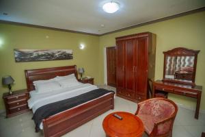 a bedroom with a bed and a table and a chair at Large Cozy room including free breakfast in Lubumbashi +8 photos