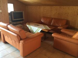 een woonkamer met banken en een tafel en een televisie bij Wenz Wohnung in Schwarzsee