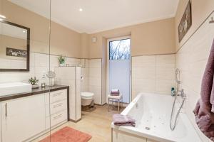 Un baño con bañera, lavabo e inodoro. en Relax Bungalow Muschelstrand, en Fehmarn 12 fotos más