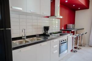 een keuken met witte apparatuur en rode muren bij Modern 1-bedroom-apartment 2 km from Eagle beach in Palm-Eagle Beach