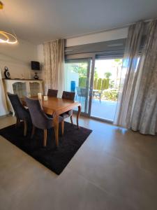 een eetkamer met een houten tafel en stoelen bij Vista bella golf beach in Orihuela