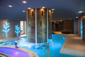 a swimming pool with a tub in a hotel at Château d'Augerville Golf & Spa Resort - TemptingPlaces Collection in Augerville-la-Rivière