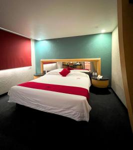 una camera da letto con un grande letto con una coperta rossa e bianca di Autoparador Del Valle a Città del Messico